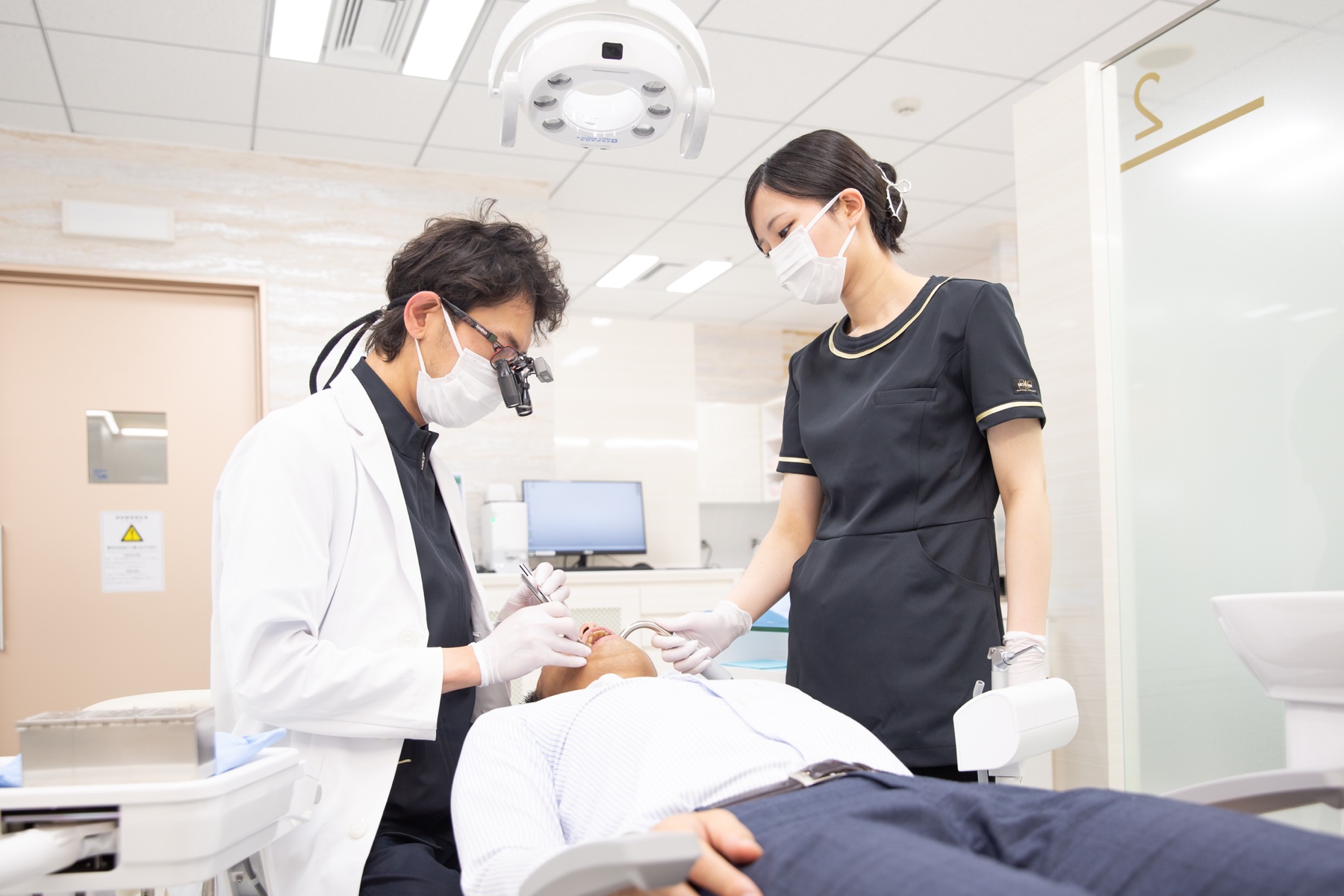 歯科医師とスタッフが連携して診療する様子