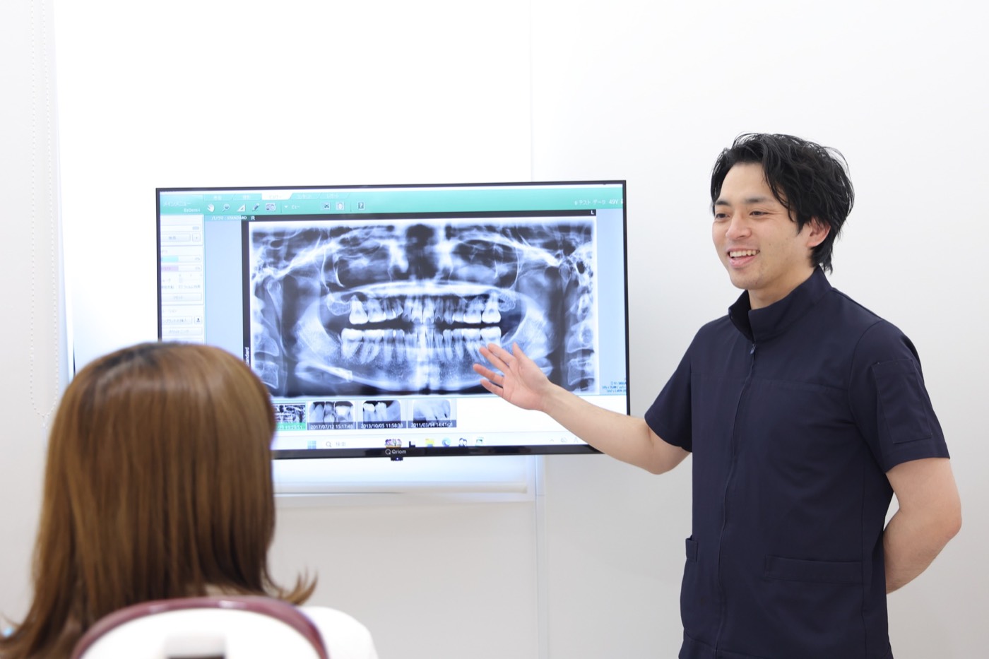 患者様へ画像を用いて説明する歯科医師